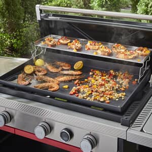 Weber Slate griddle with lid up cooking prawns, peppers and onions